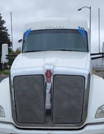 Kenworth semi tractor with a new windshield taped while the urethane cures